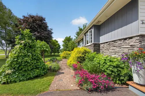 A flower-lined path along the side of the house
