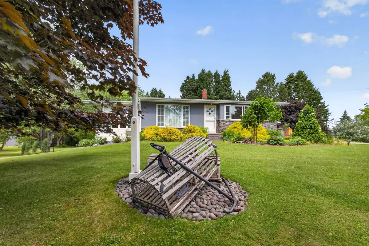 A handmade garden sculpture with the house beyond it