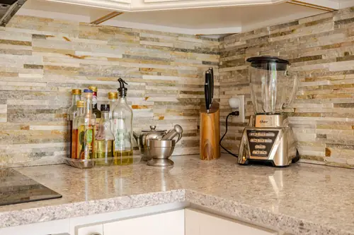 The kitchen counter and the stone backsplash