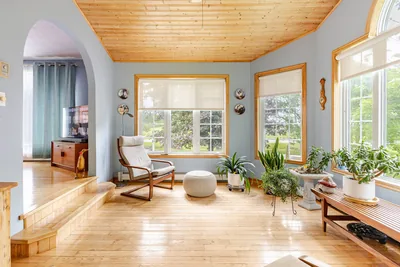 The sunroom, with its wood ceiling, plants and windows on three sides